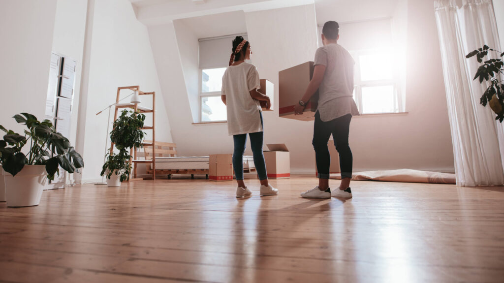 Learn how to get your Long Beach, CA rental home ready between tenants. Couple holding boxes while moving into their Long Beach rental property.