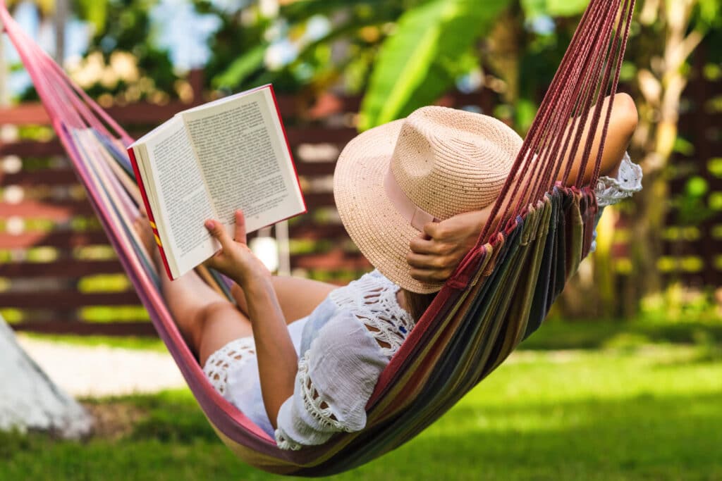 Southern California property owner relaxes in a hammock while reading a book.